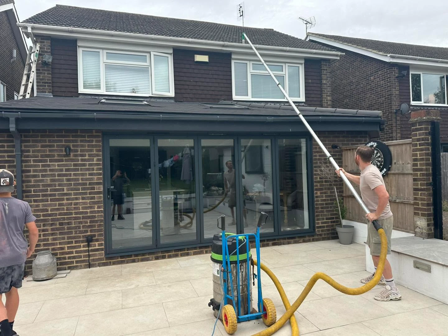 Pressure washing the roof of a house.