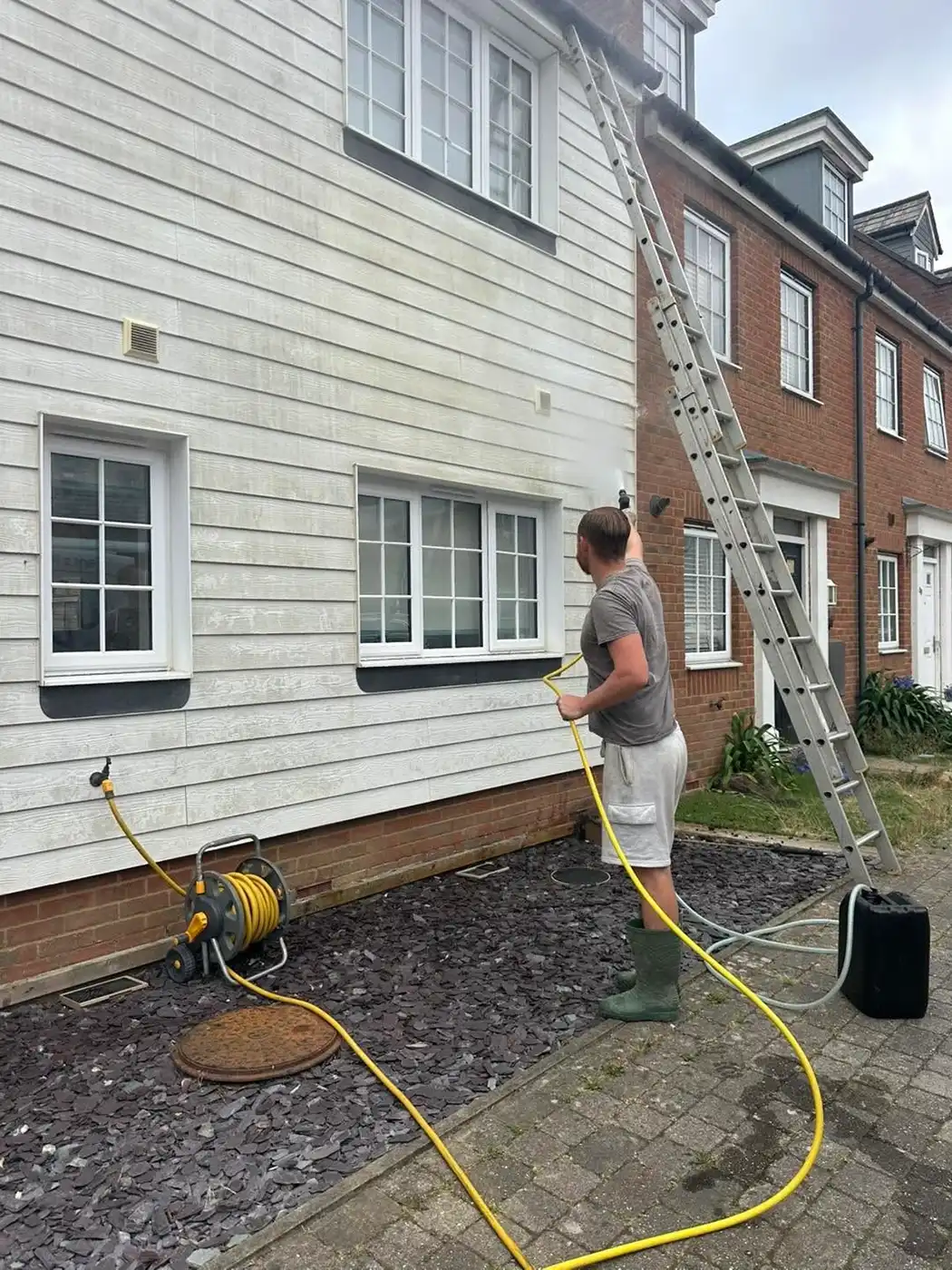 Pressure washing a white house.