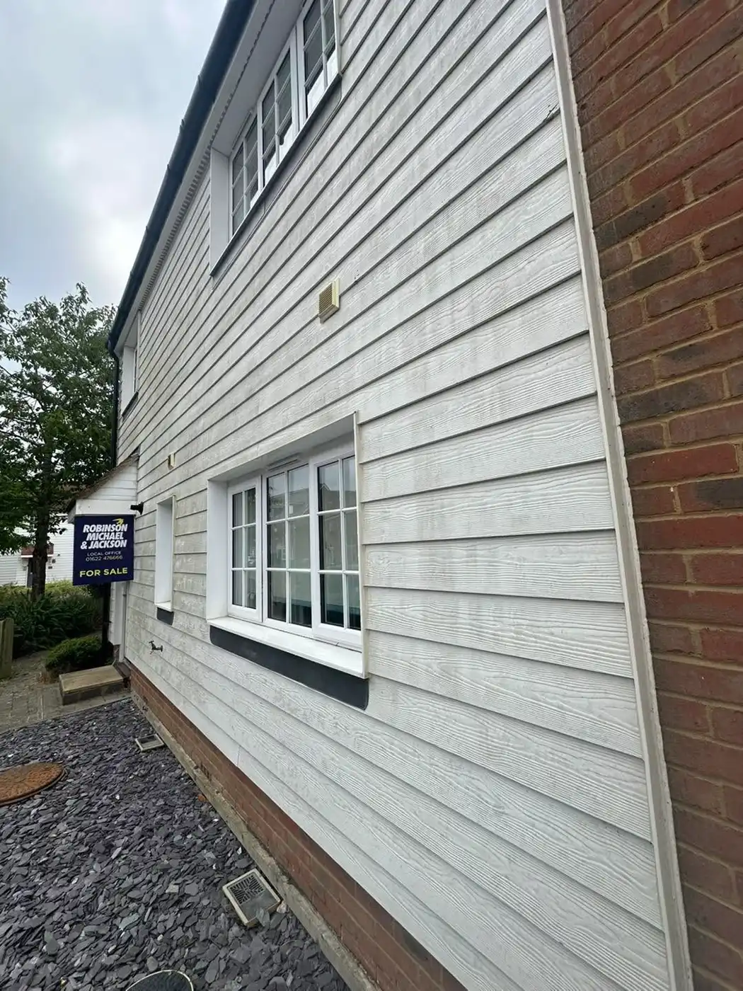 White slatted house being cleaned.