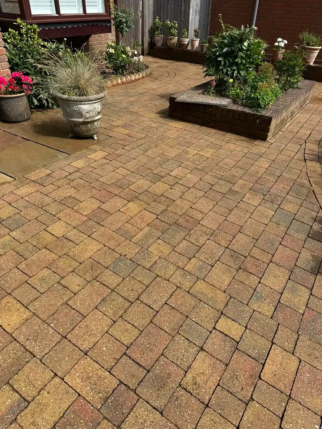 Block paved patio being cleaned.