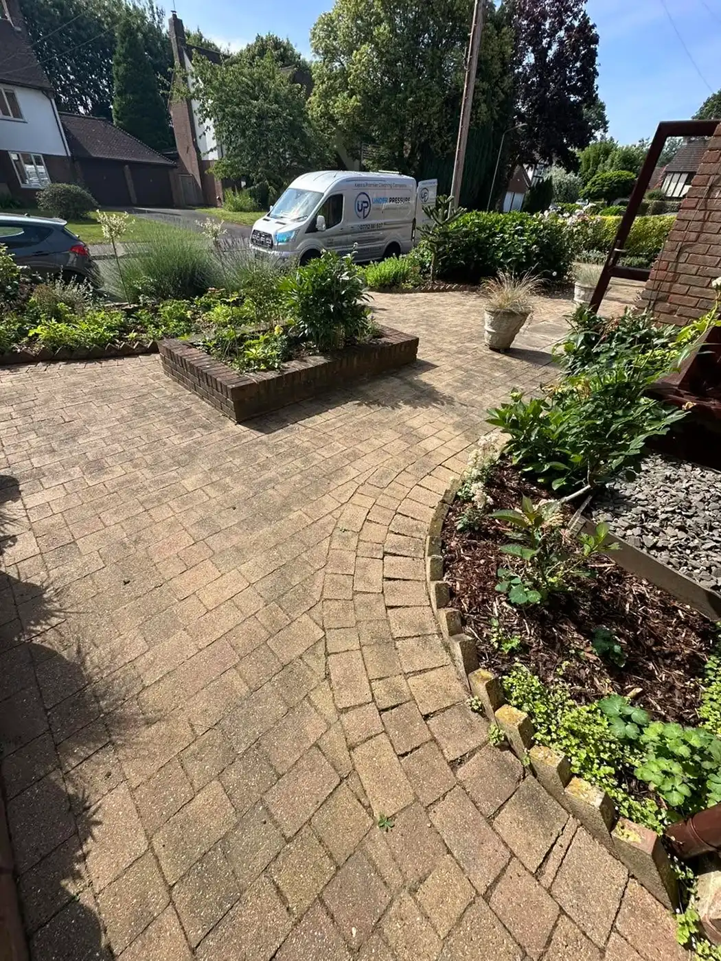 Block paving with curved garden.